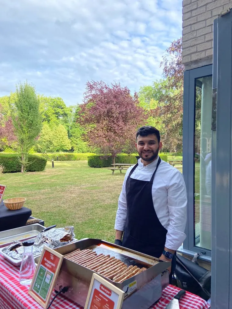 Chef préparant un barbecue en extérieur dans un jardin