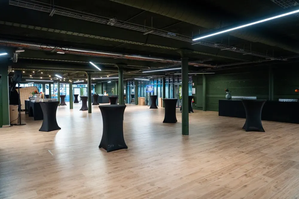 Salle du Gong installée en configuration cocktail avec mange-debout, structure industrielle aux poteaux verts