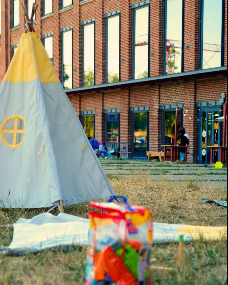 Tipi et coin jeux pour enfants installés sur la pelouse devant Le Gong